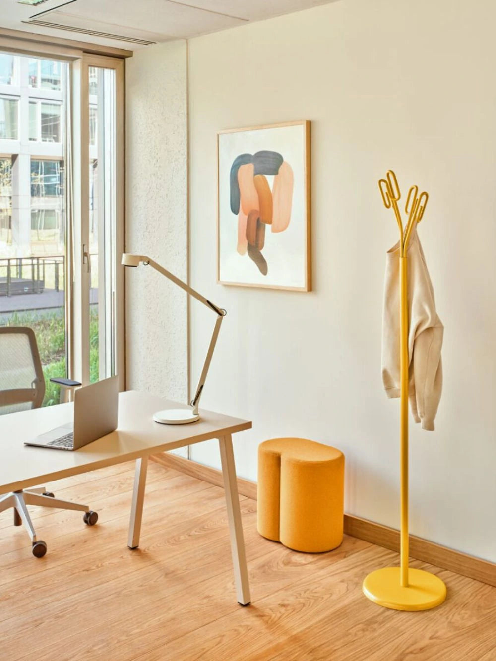 Clip Steel Coat Stand in Yellow Finish with Light Orange Pouufe and Rectangular Desk in Modern Office Setting