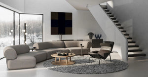 Daaz Modular Seating in Different Configurations with Round Coffee Table and Black Leather Armchair in Living Area Setting
