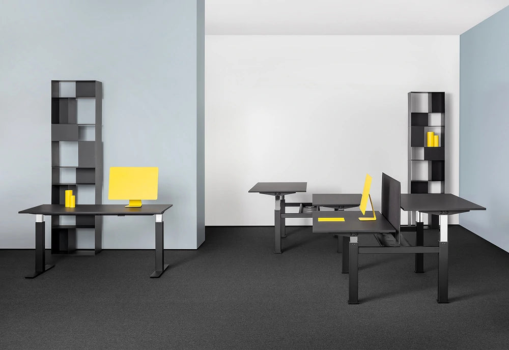 Mara Follow Height Adjustable Office Desk In Black Finish With Grey Shelves In Office Setting