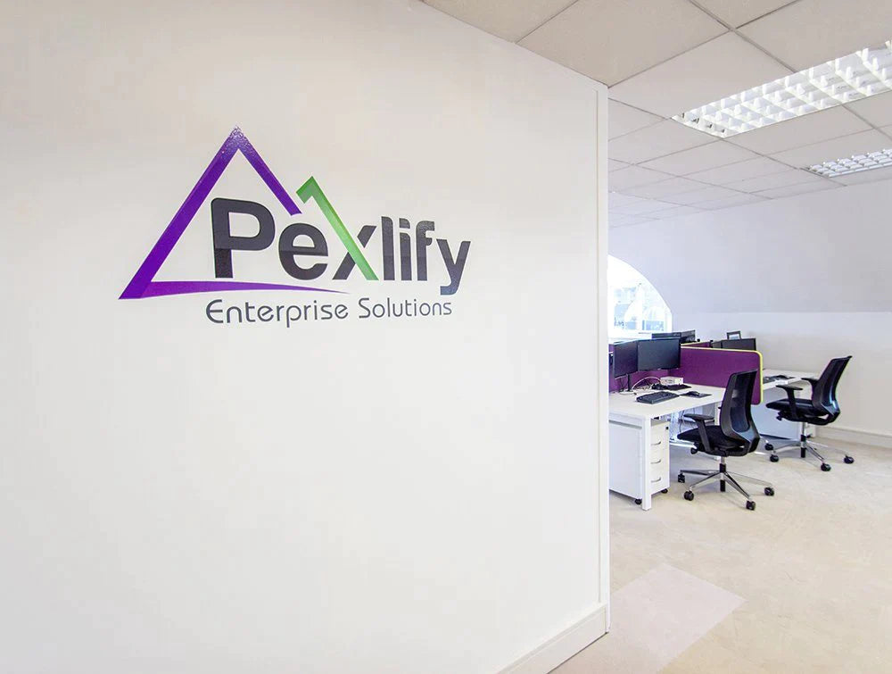 Pexlify Logo On White Wall With Desks In Background