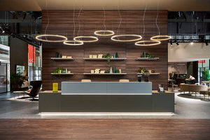 Quadrifoglio Z1 Reception Desk In Grey Finish With Wooden Wall Shelves With Small Coffee Table In Reception Setting