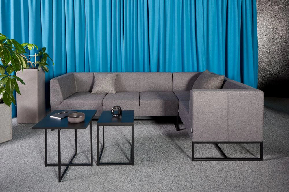 Quick Square Reception Table in Black with Grey Sofa and Grey Acoustic Planter in Living Room Setting