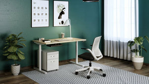 RoundE Bamboo Sit Stand Desk with White Pedestal and White and Black Armchair in Home Office Setting