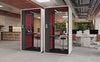Smart Office Hush Free S Acoustic Phonebooth in White with Red Interior with Black Top Table and Black Movement Stool in Modern Office Setting