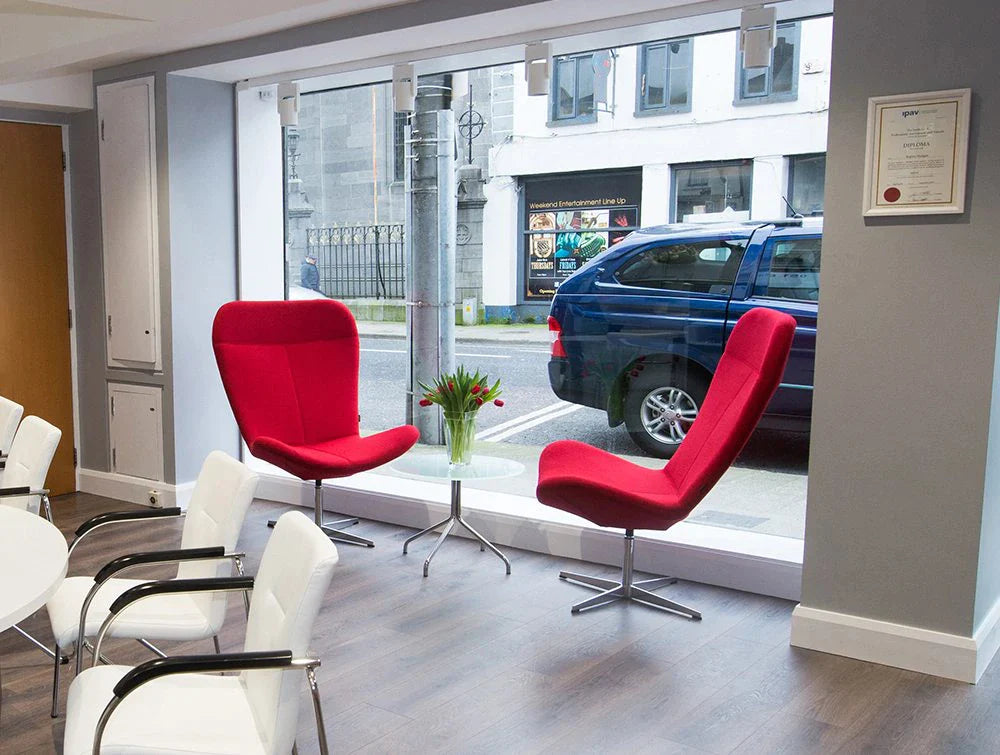 Two Red Chairs And Several White Chairs In Front Of Window